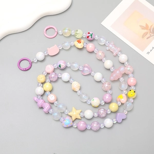 Détail macro de la lanière de téléphone en perles macaron avec breloques ours et cœur