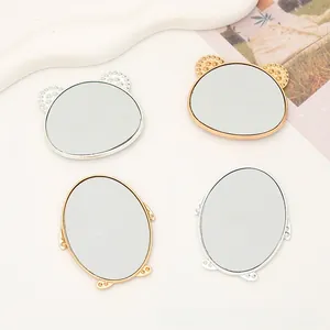 Close-up of DIY bear shaped phone mirror with gold and silver rhinestone borders