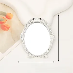 Detailed view of penguin-shaped portable mirror with shiny rhinestones and dimensions