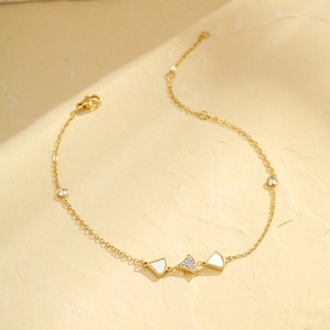 Détail du bracelet de cheville doré avec feuille de ginkgo en nacre et cristaux