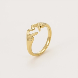 Close-up of adjustable gold-colored ring featuring a unique two-hand heart-shaped design