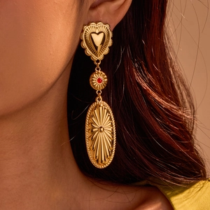 Bohemian gold long drop earrings with heart and oval sunburst details on model