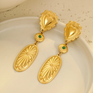 Bohemian gold heart earrings with green bead and sunburst oval pendant on ceramic tray