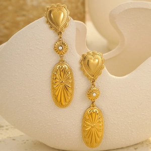 Detail of vintage gold heart earrings with white pearls and sunburst oval pendants