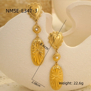 Detailed view of vintage gold bohemian earrings with heart shape and white pearl accents
