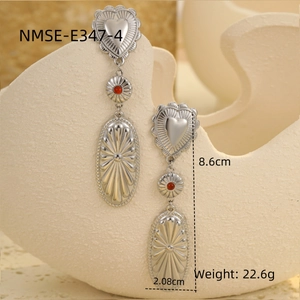 Detail shot of bohemian silver drop earrings with heart and red bead elements