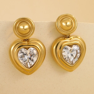 French vintage gold heart drop earrings with zircon inlay on a beige display stand