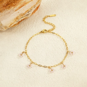 Detail of gold chain bracelet featuring five pink flower charms with beaded crystal petals