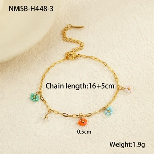 Detail of gold chain bracelet with colorful beaded flower pendants and lobster clasp closure
