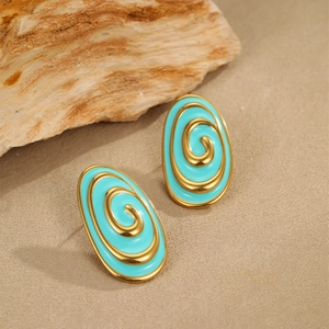 Detailed shot of oval turquoise enamel stud earrings with golden spiral design on a stone