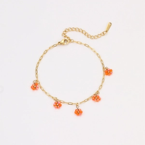 Detail of gold stainless steel chain bracelet with five orange beaded flower charms