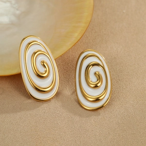 Detailed shot of oval gold-plated earrings with white enamel and spiral texture patterns