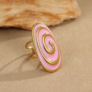 Macro shot of pink enamel oval ring with gold spiral design and double-layered band