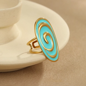 Macro shot of gold oval ring with blue spiral enamel pattern and adjustable open band