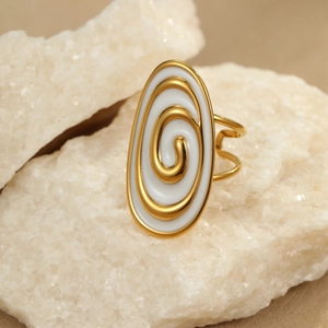 Golden oval ring with white enamel and spiral texture on white mineral stone