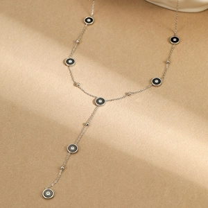 Detail van een zilveren Y-vormige ketting met zwarte emaille bedels en witte fonkelstenen