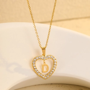 Macro shot of 18K gold plated heart pendant with zircon accents and letter D detail