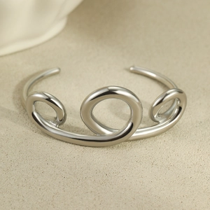 Detailed view of silver stainless steel cuff bracelet with triple abstract curved rings