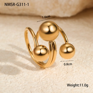 Detailed close-up of gold spiral ring with three polished beads on textured stone