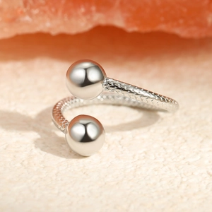 Detailed macro view of silver titanium steel ring with fish scale texture and two metal beads