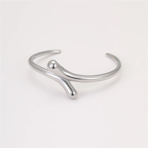 Detailed macro view of silver minimalist open bangle with molten metal flowing design