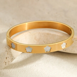 Gouden roestvrijstalen armband met elegante witte parelmoer bloemmotieven erop