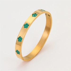 Detailopname van het scharnier op de goudkleurige armband met groene bloemen