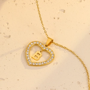 Detail of 18K gold heart necklace with sparkling zircon frame and letter B pendant