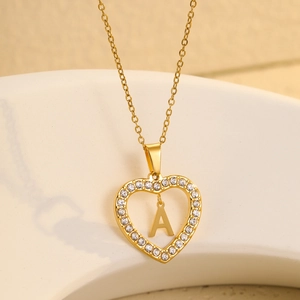 Detailed macro of gold heart pendant necklace with shimmering crystals and letter A