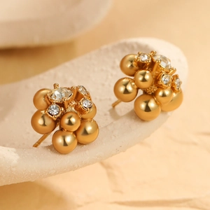 Chic golden flower cluster stud earrings with zircon accents on a textured stone surface