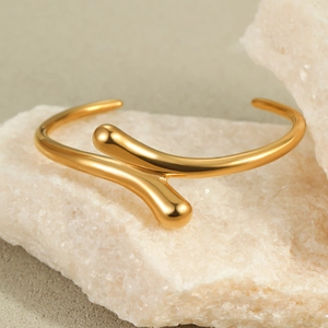 Detailed macro view of 18K gold plated minimalist knotted stainless steel bracelet