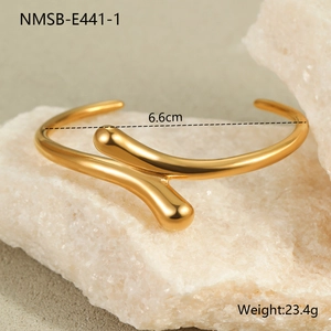 Detail shot of a minimalist 18K gold-plated knotted cuff bracelet with size measurements