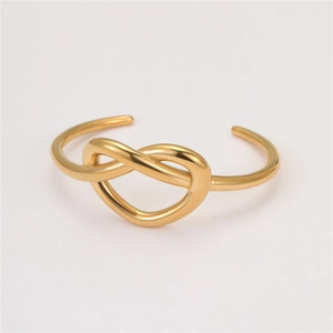 Detail view of gold-plated stainless steel knotted bracelet with a polished finish