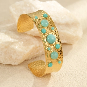 Détail d'un bracelet jonc doré martelé en acier inoxydable avec pierres turquoises de bohème
