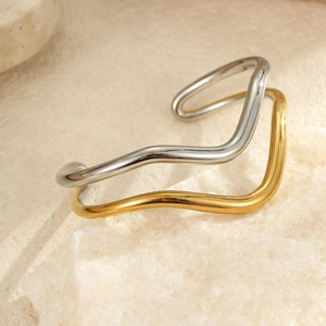 Detalle del brazalete geométrico bicolor de acero inoxidable con ondas de oro y plata