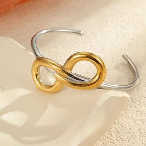 Detalle de brazalete bicolor con símbolo de infinito sobre una bandeja de piedra