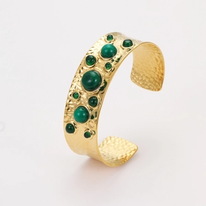 Détail du bracelet manchette doré martelé avec pierres vertes incrustées et style rétro