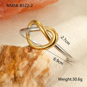 Primer plano de un brazalete de acero inoxidable bicolor con diseño de nudo geométrico