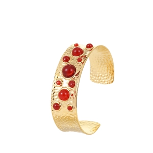 Bracelet manchette vintage en acier doré avec pierres rouges et texture martelée
