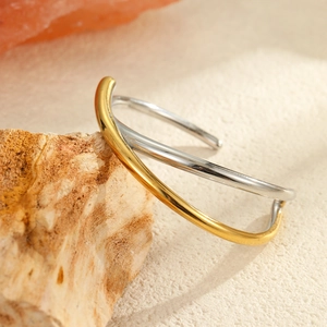 Vista detallada del brazalete bicolor entrelazado de acero inoxidable dorado y plateado