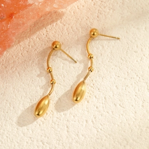 Detail van gouden waterdruppel oorbellen met slangenketting en metalen kralen