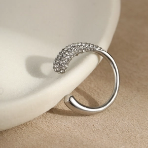 Makroaufnahme einer silbernen Earcuff mit polierter Metallperle und Zirkonia-Besatz
