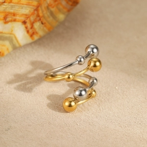 Macro shot of spiral wrap stainless steel ring with polished gold and silver beads