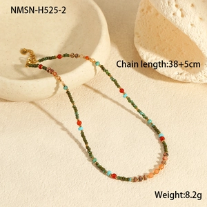 Detailed view of bohemian beaded necklace with natural stones on a ceramic tray