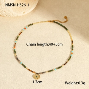 Detail view of colorful beaded necklace with gold Evil Eye charm and extension chain