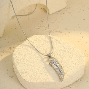 Silver horn pendant necklace with sparkling cubic zirconia on a minimalist stone base