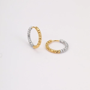 Details von zweifarbigen Edelstahl-Ohrringen in Gold und Silber mit Textur-Muster