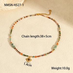 Detail of bohemian natural stone necklace with a golden sun pendant and colorful beads