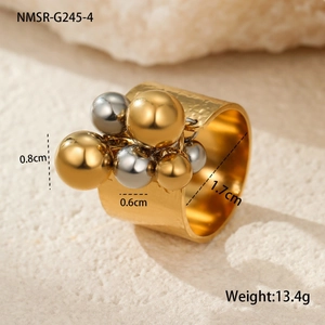 Detailed view of wide 18k gold plated ring with metallic beads on a stone surface
