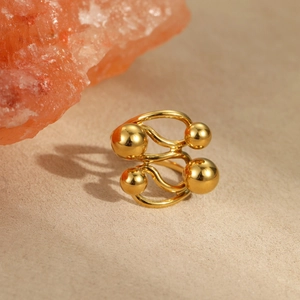 Detail of 18k gold plated stainless steel wavy ring with polished metal spheres